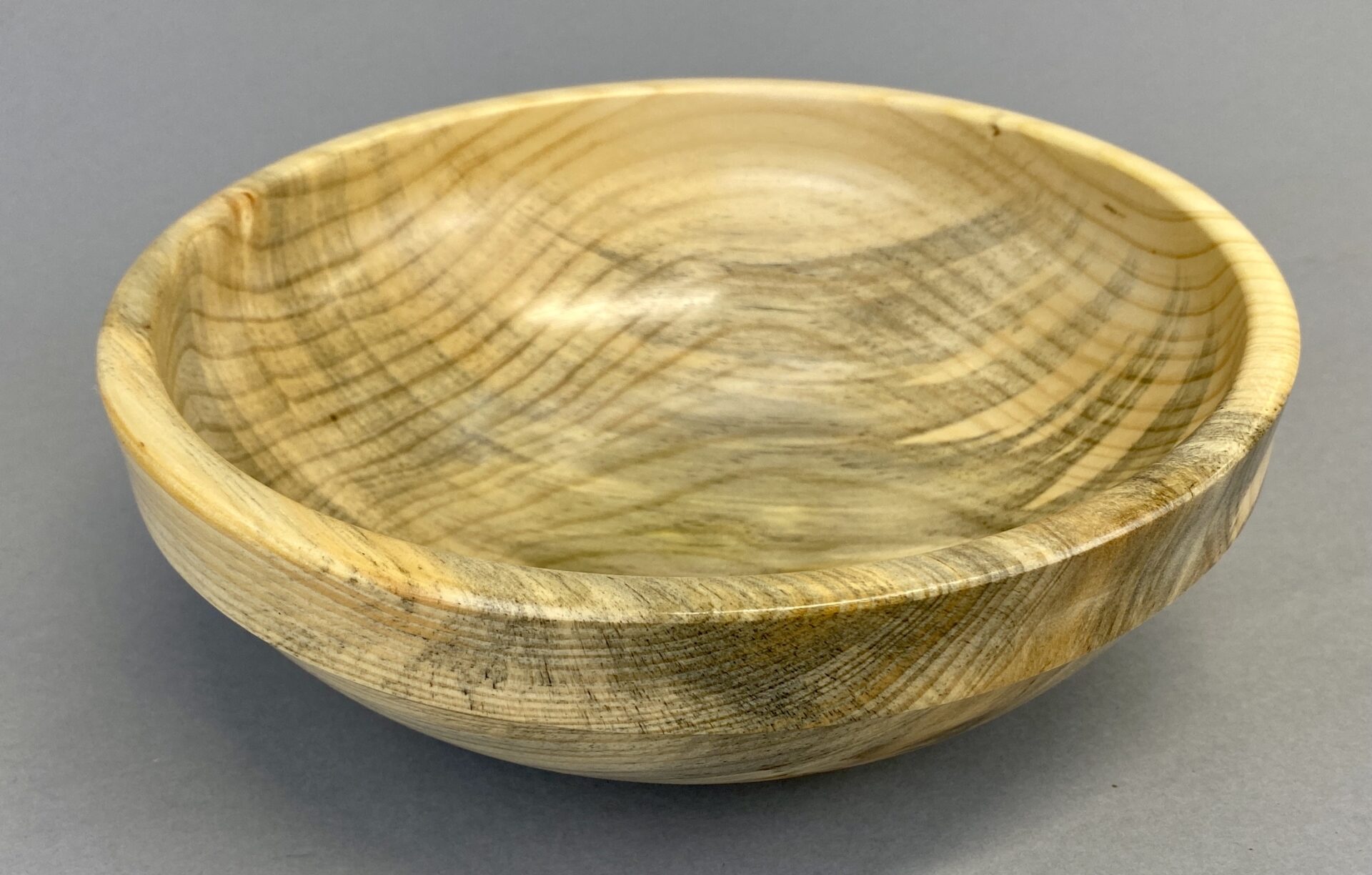 A wooden bowl with a gray background