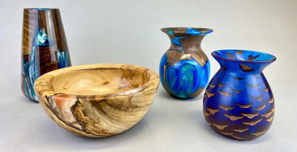 Three vases are sitting next to a bowl.