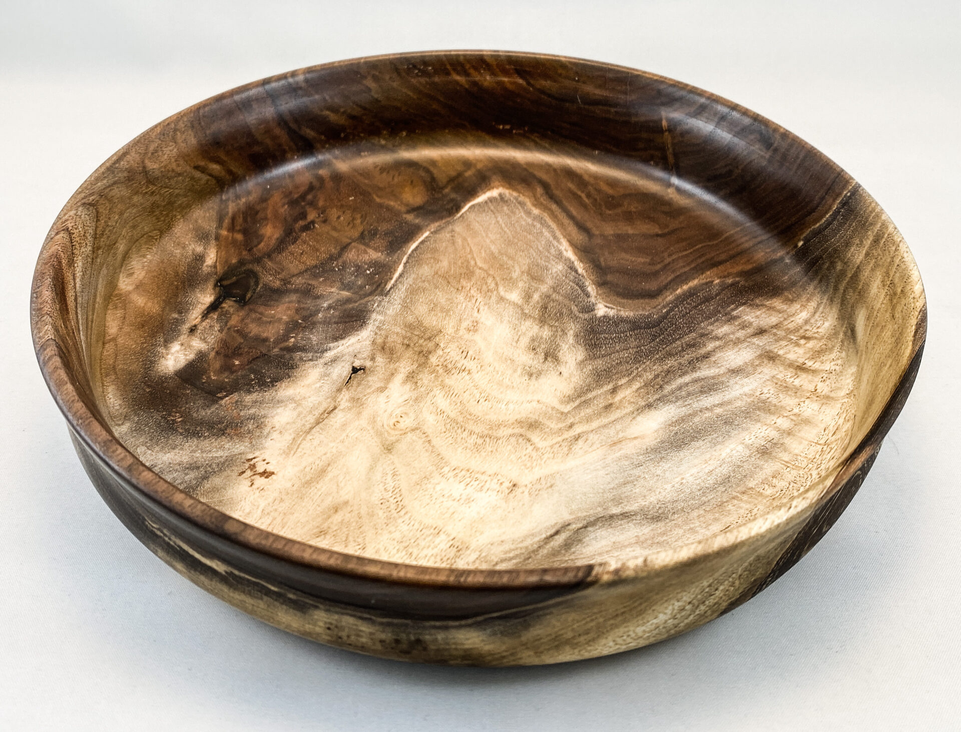 A wooden bowl with some brown and white wood