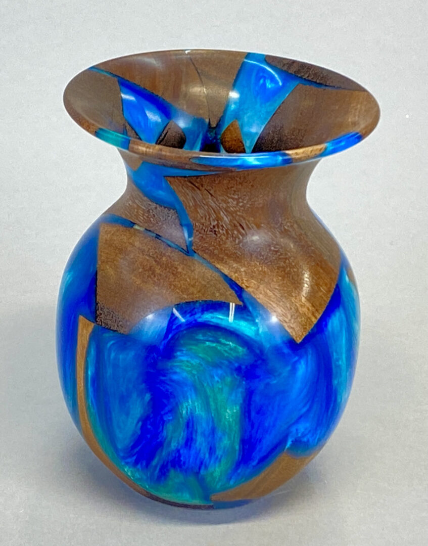 A vase with blue and brown paint on it.