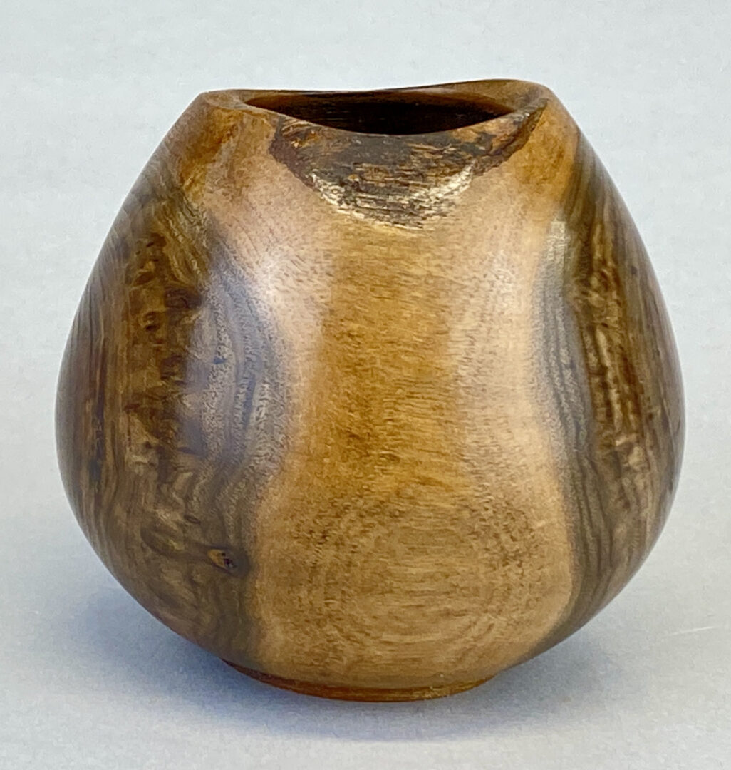 A wooden vase with a brown finish.