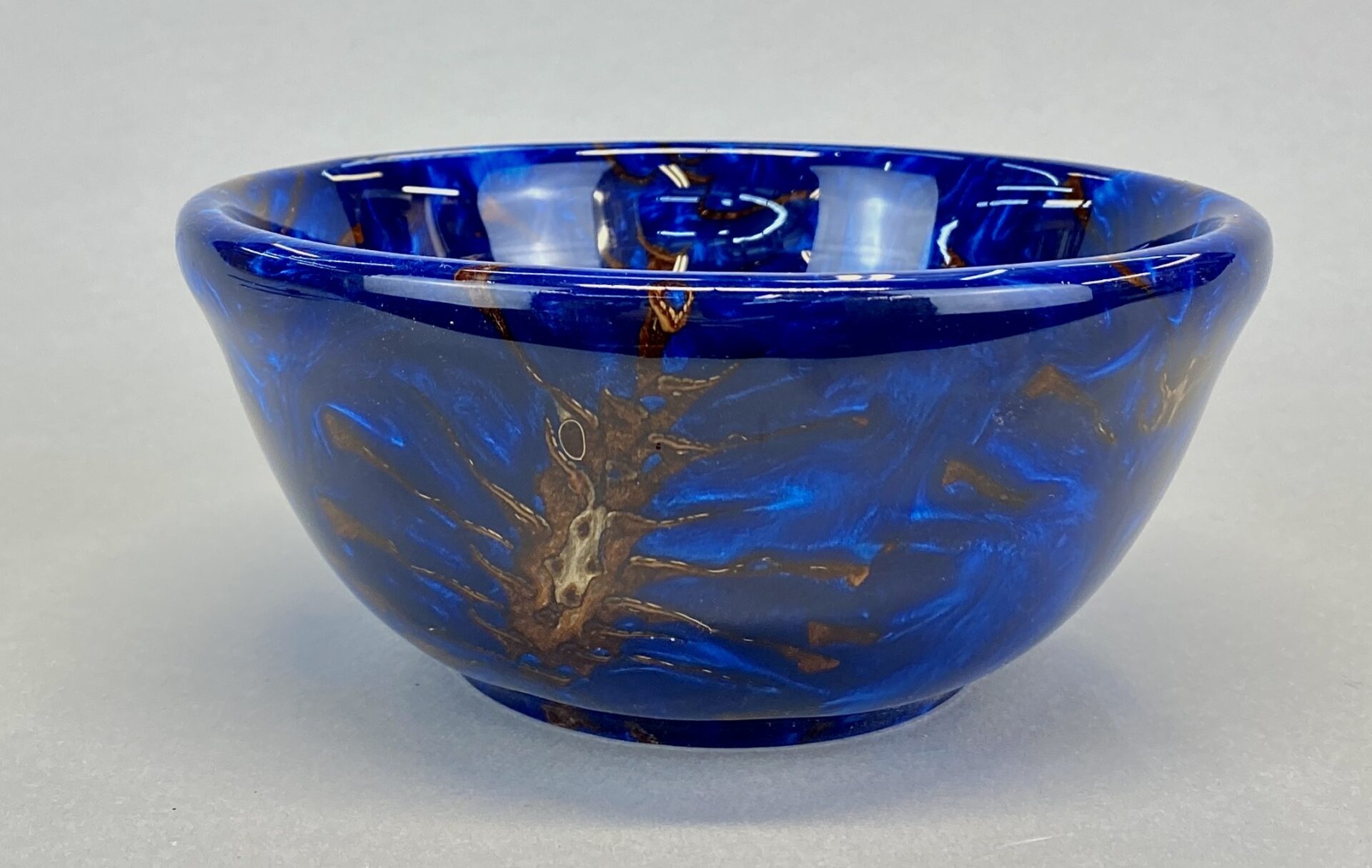 A blue bowl with brown and white designs on it.