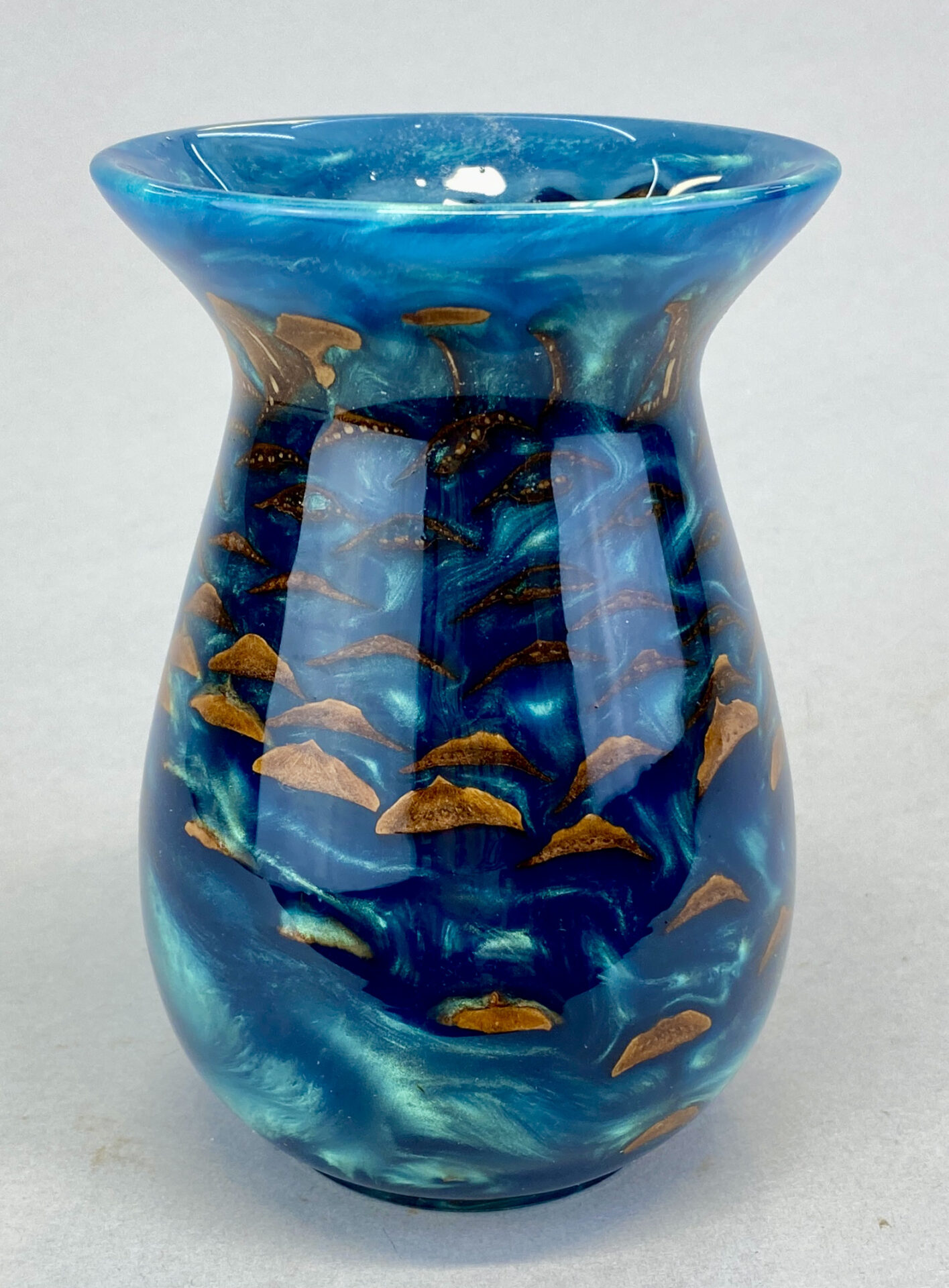 A blue vase with gold fish on it.