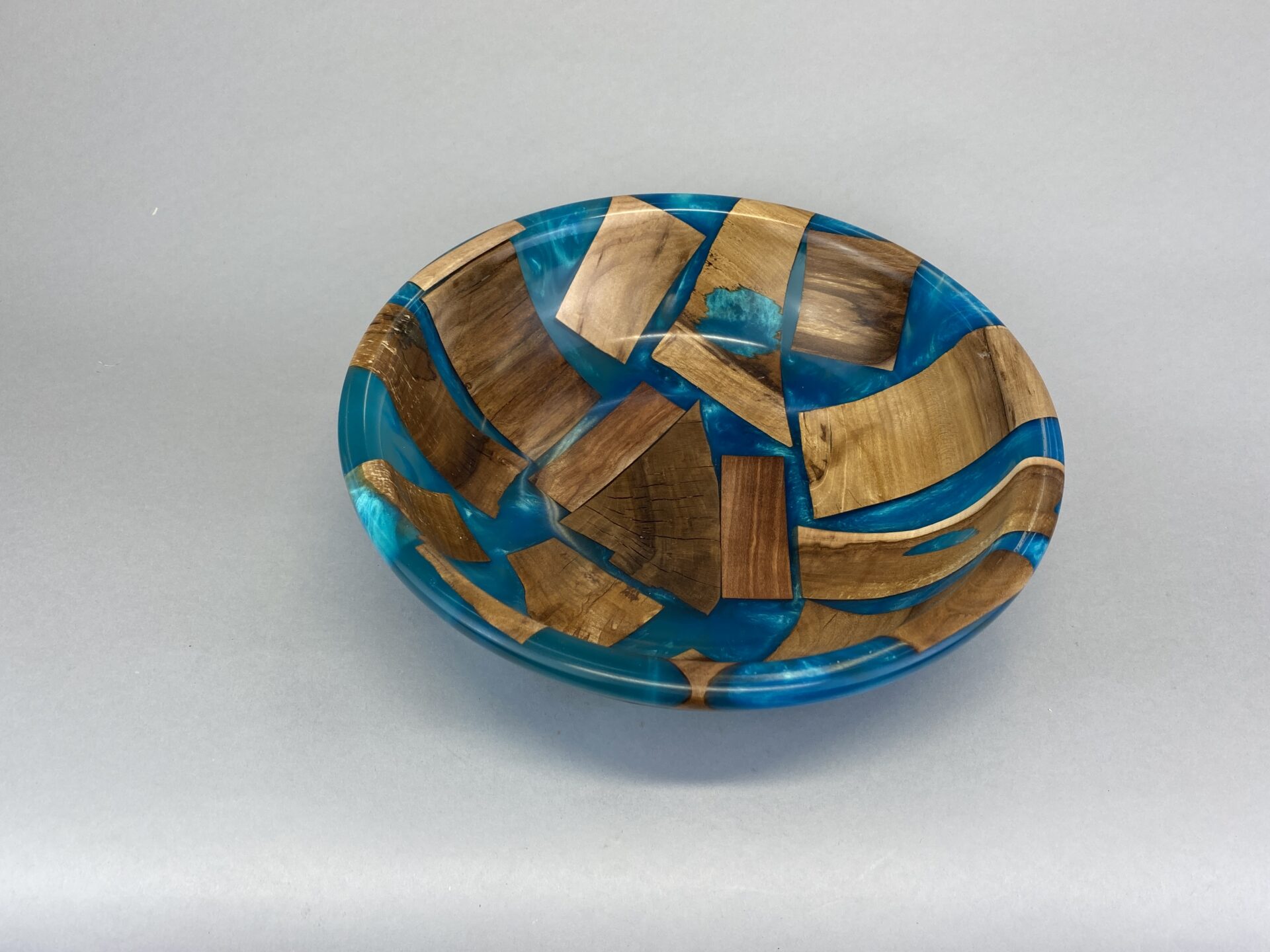 A bowl made of wood and blue epoxy.