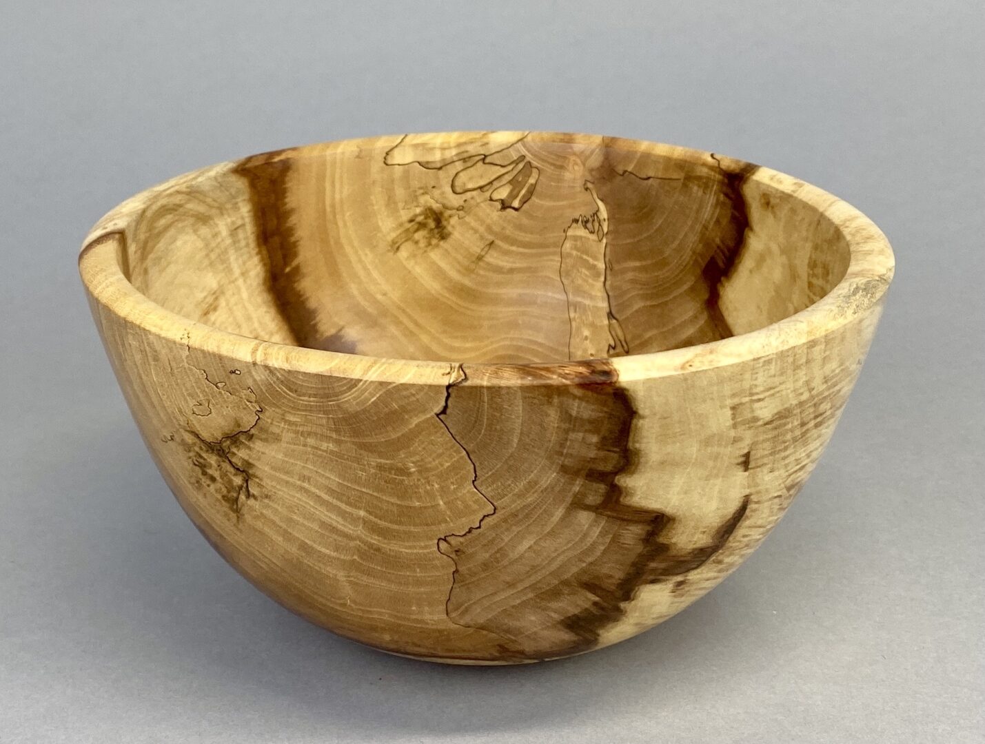 A wooden bowl with a pattern of wood grain.