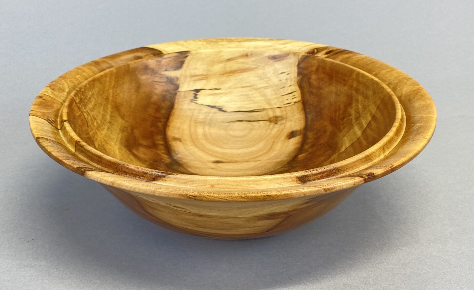 A wooden bowl with two sections of wood on it.