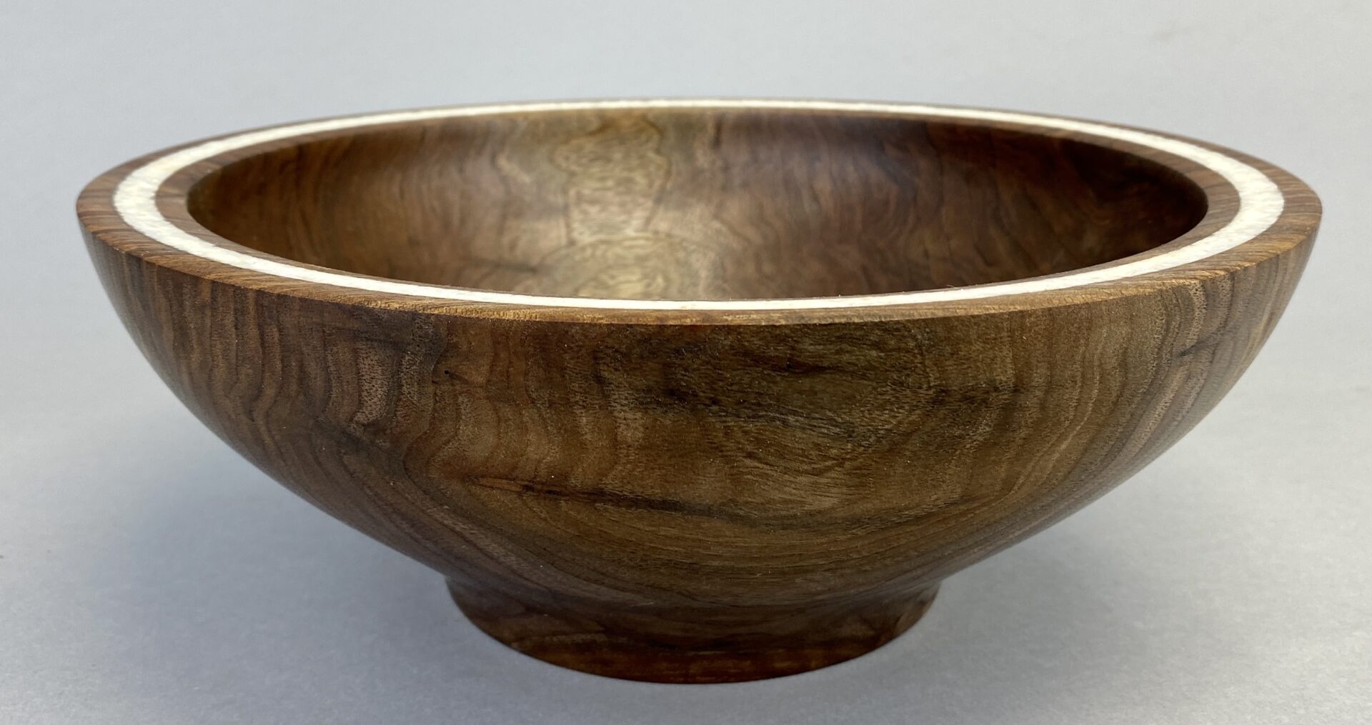 A wooden bowl sitting on top of a table.