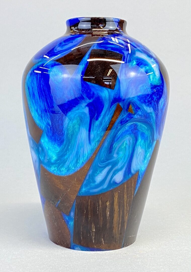 A blue vase with brown and black swirls