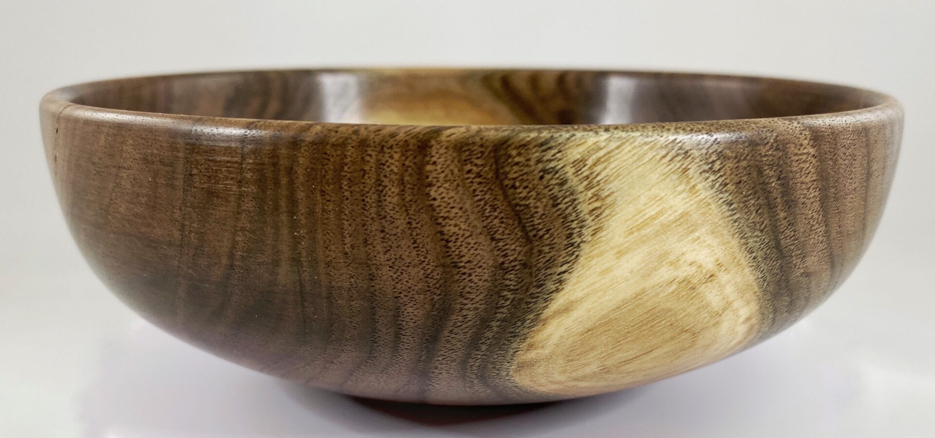 A wooden bowl with brown and black wood grain.