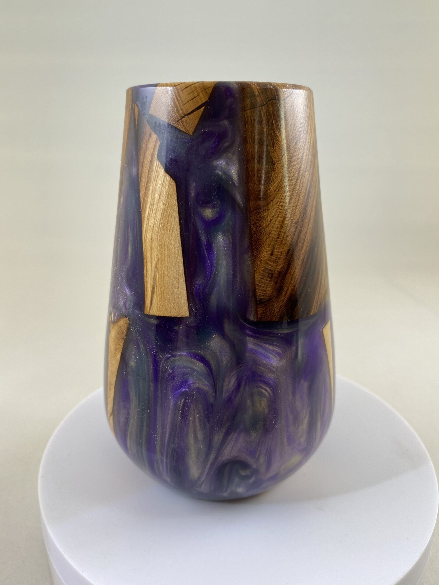 A vase made of wood and purple resin.