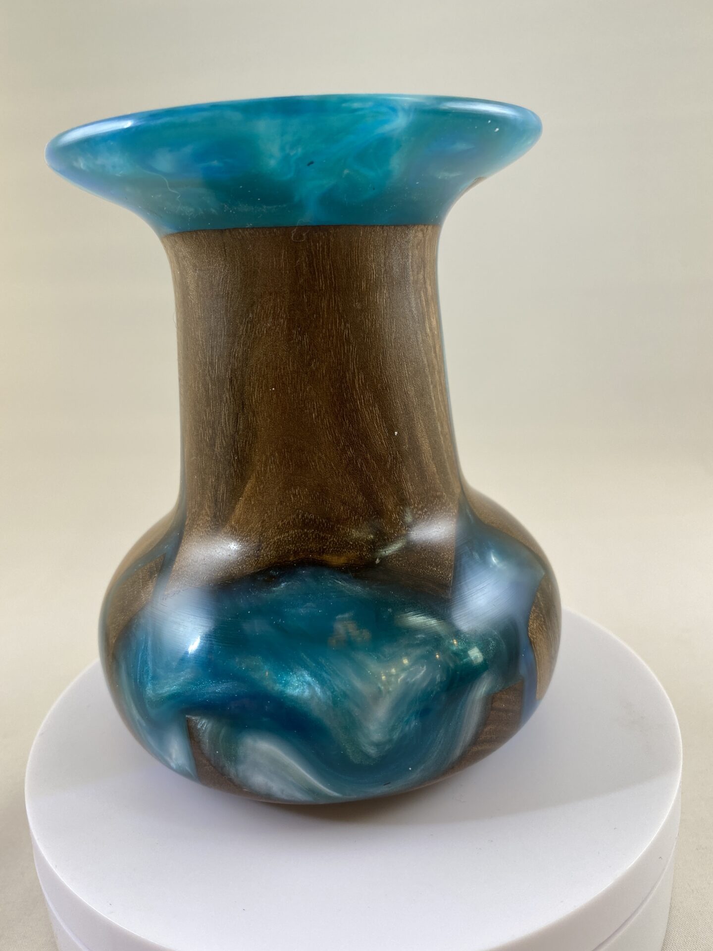 A blue and brown vase sitting on top of a white plate.