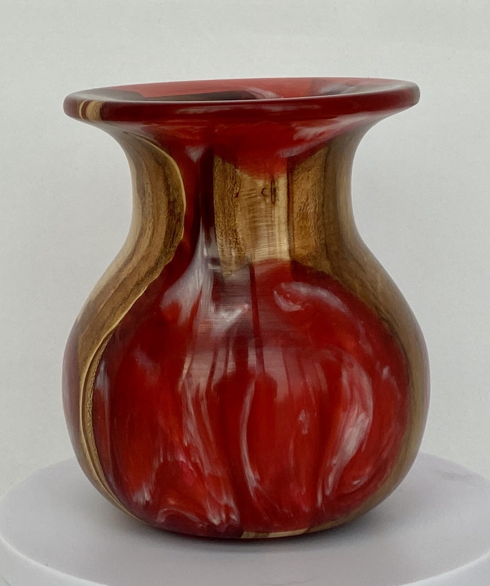 A red vase with brown stripes on the bottom.