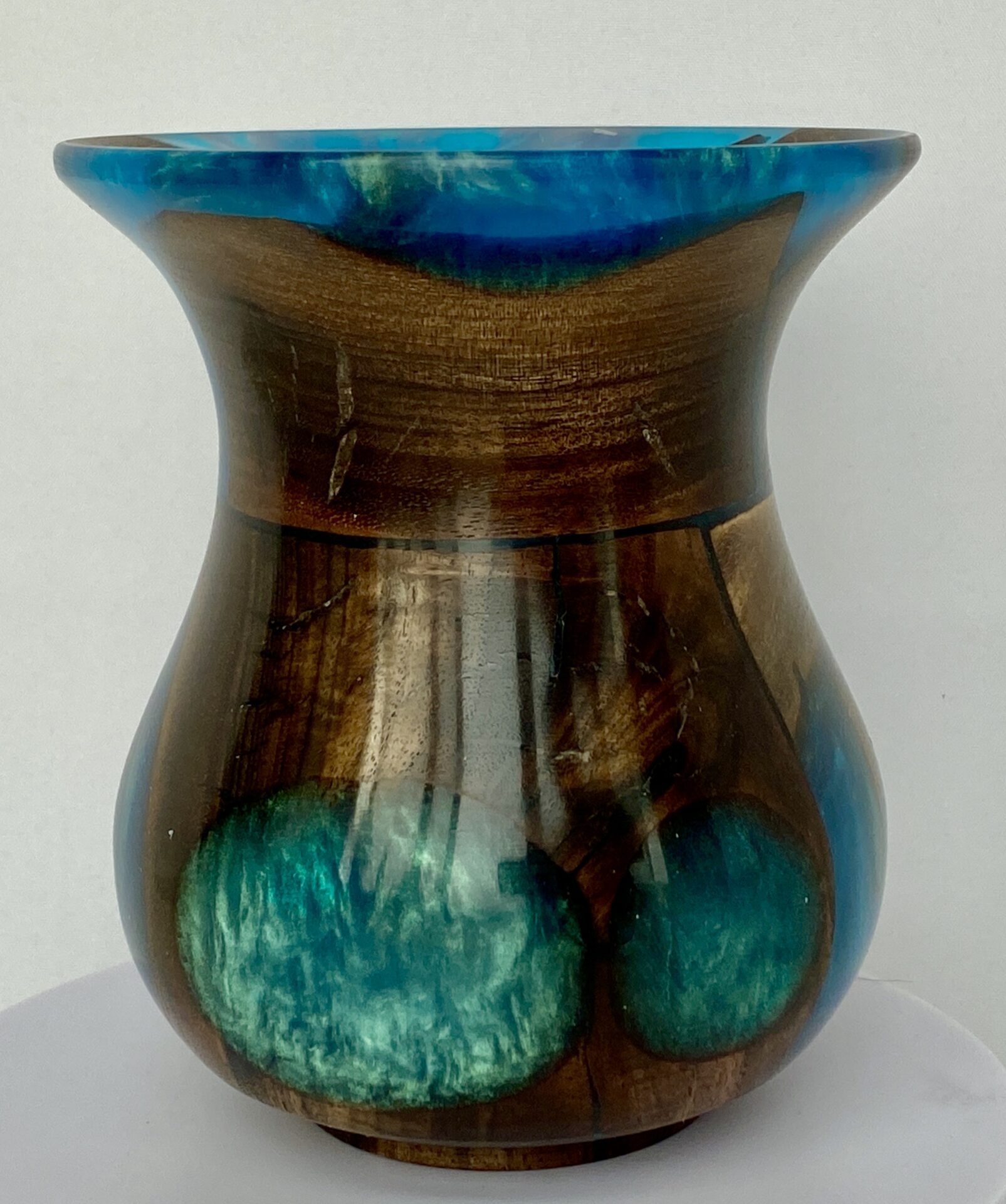 A vase with blue and brown paint on it.