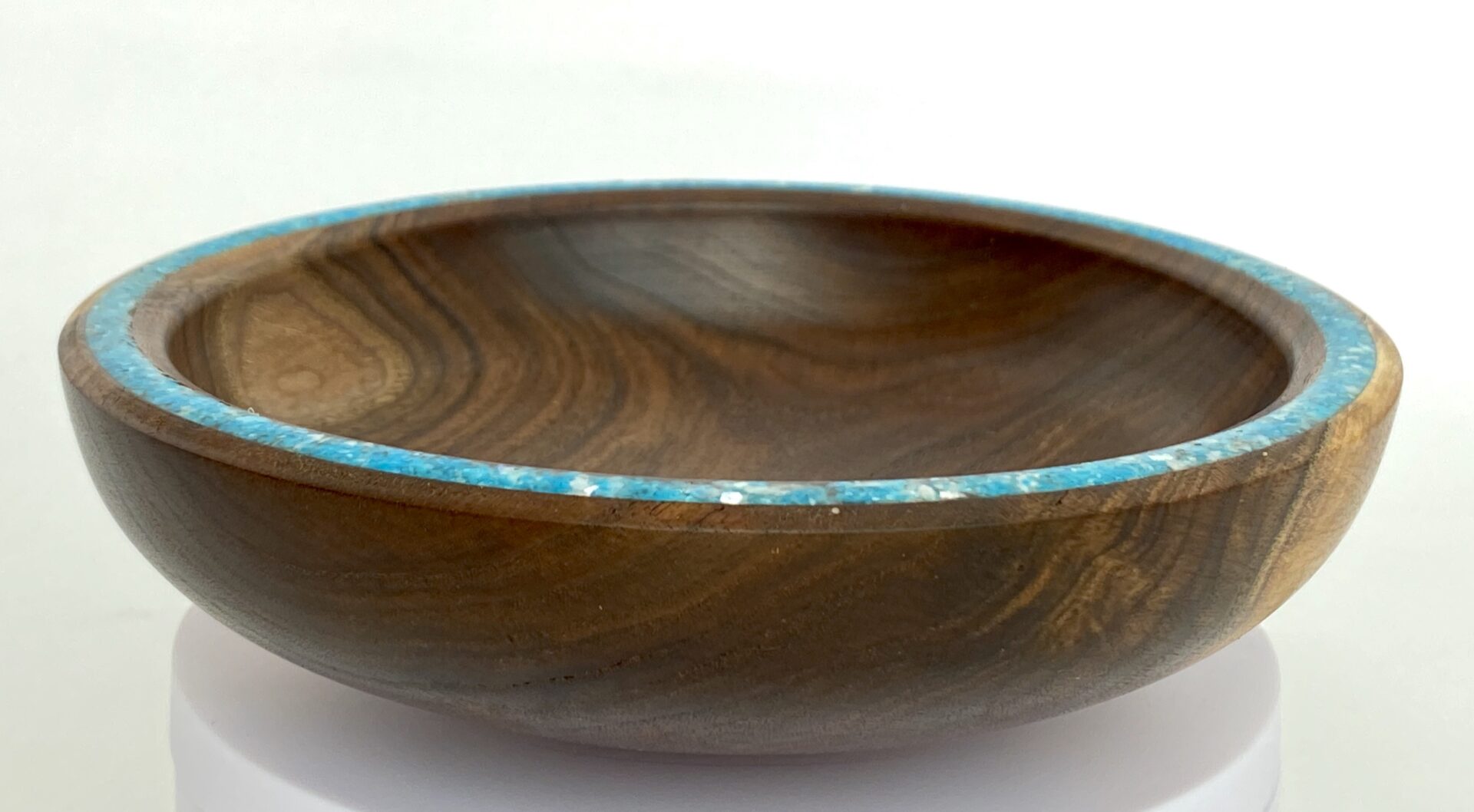 A wooden bowl with blue trim on top of a table.