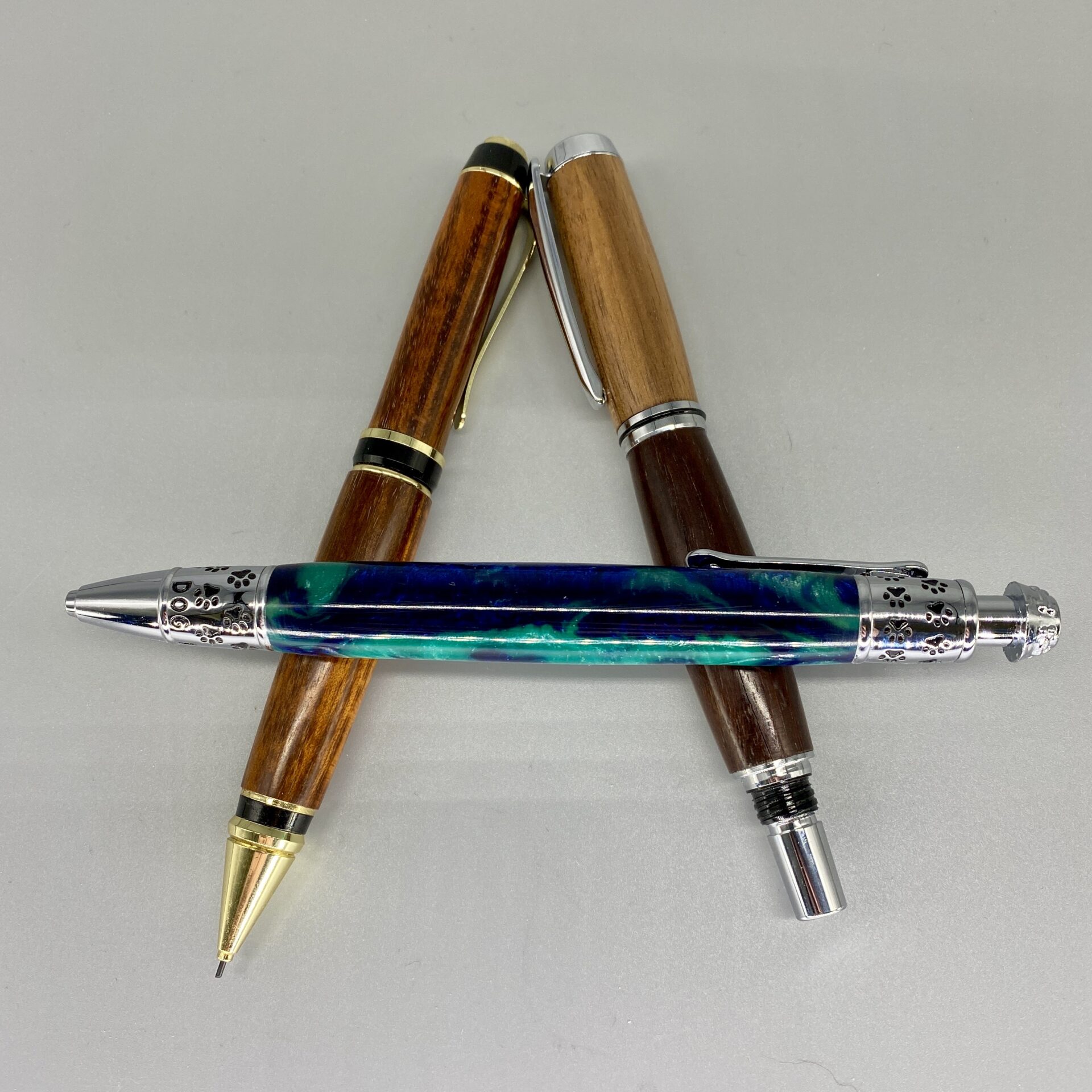 Three pens are sitting on a table together.