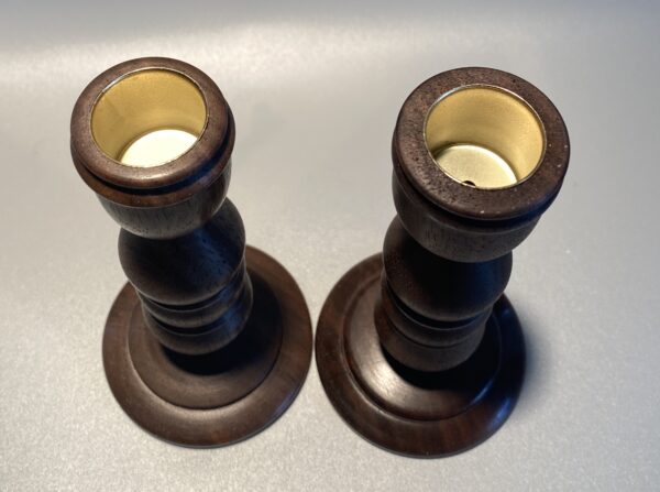 Two wooden candle holders with a white background