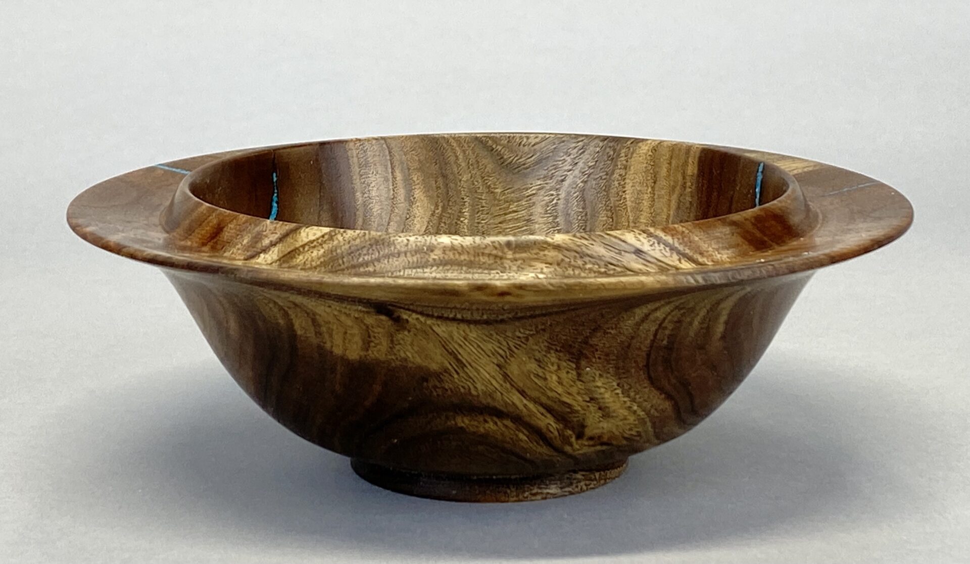 A wooden bowl sitting on top of a table.