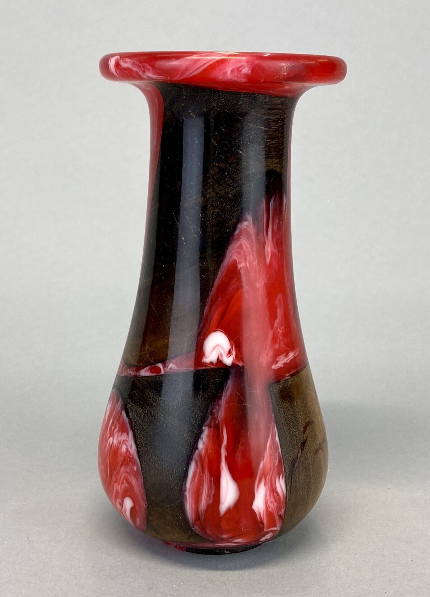 A red and black vase with a white background