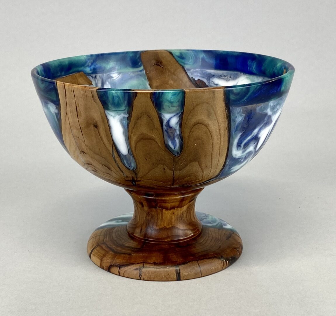 A wooden bowl with blue and white glaze on top of it.