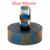 A blue macaw ring sitting on top of a wooden block.