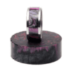 A purple and black ring is on top of a wooden block.