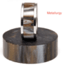 A metal ring sitting on top of a wooden block.