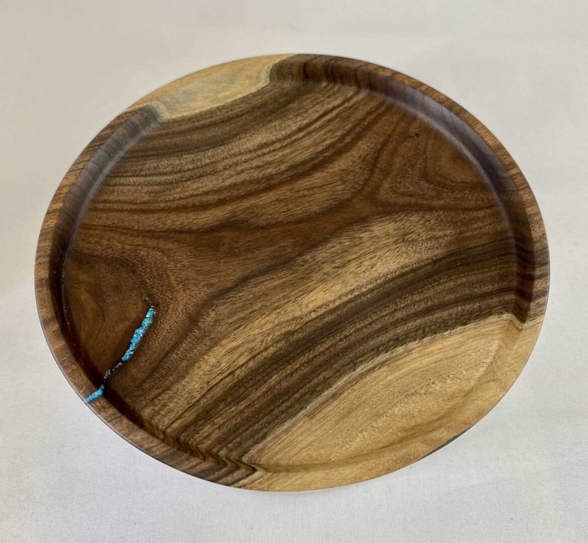 A wooden plate with a blue stripe on it