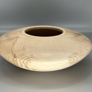 A wooden bowl with a brown rim on top of a table.