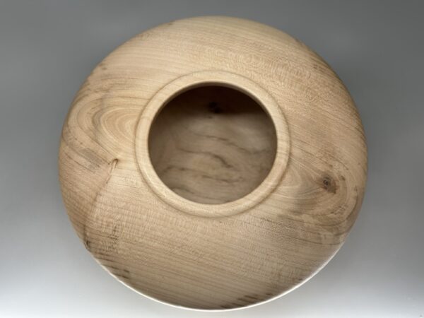 A wooden bowl with a hole in the middle.