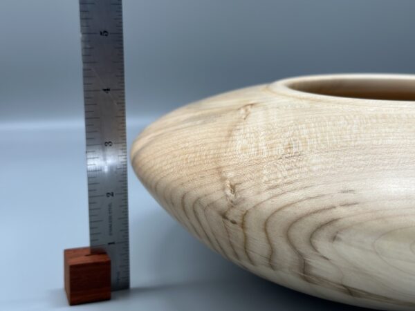 A wooden bowl sitting next to a ruler and a wood block.