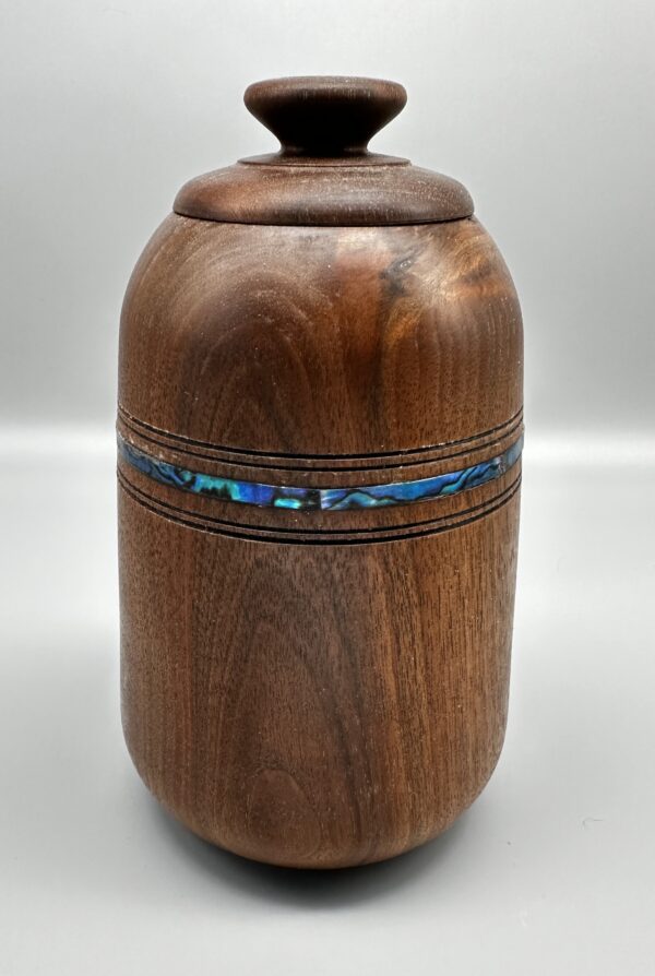 A wooden urn with a blue inlay on top of it.