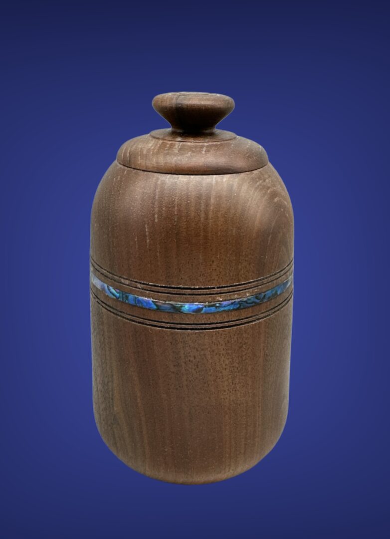 A wooden vase with a blue stripe around the bottom.