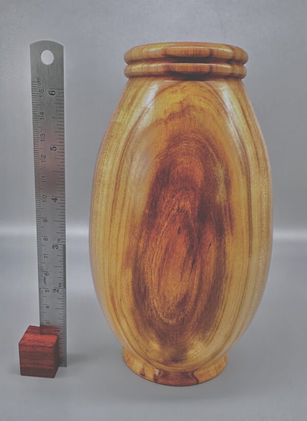 A wooden vase with a ruler and a pencil