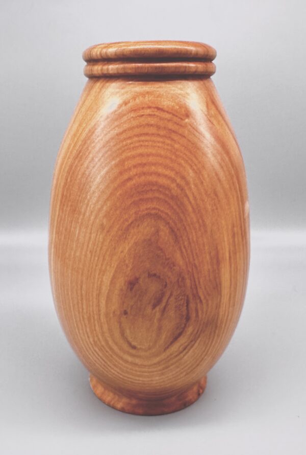 A wooden vase with a lid on top of it.