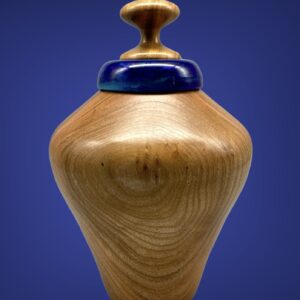 A wooden vase with blue top on a table.