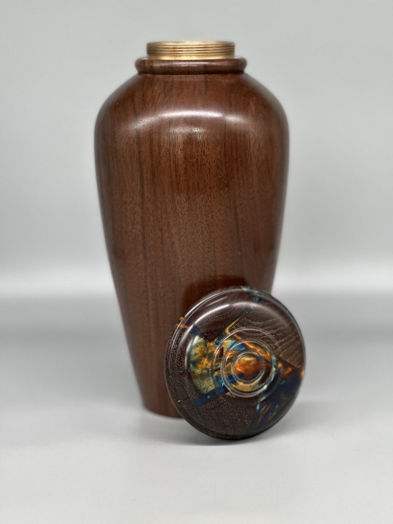 A wooden urn with a lid on top of it.