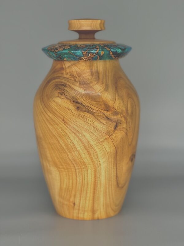 A wooden vase with a lid on top of it.