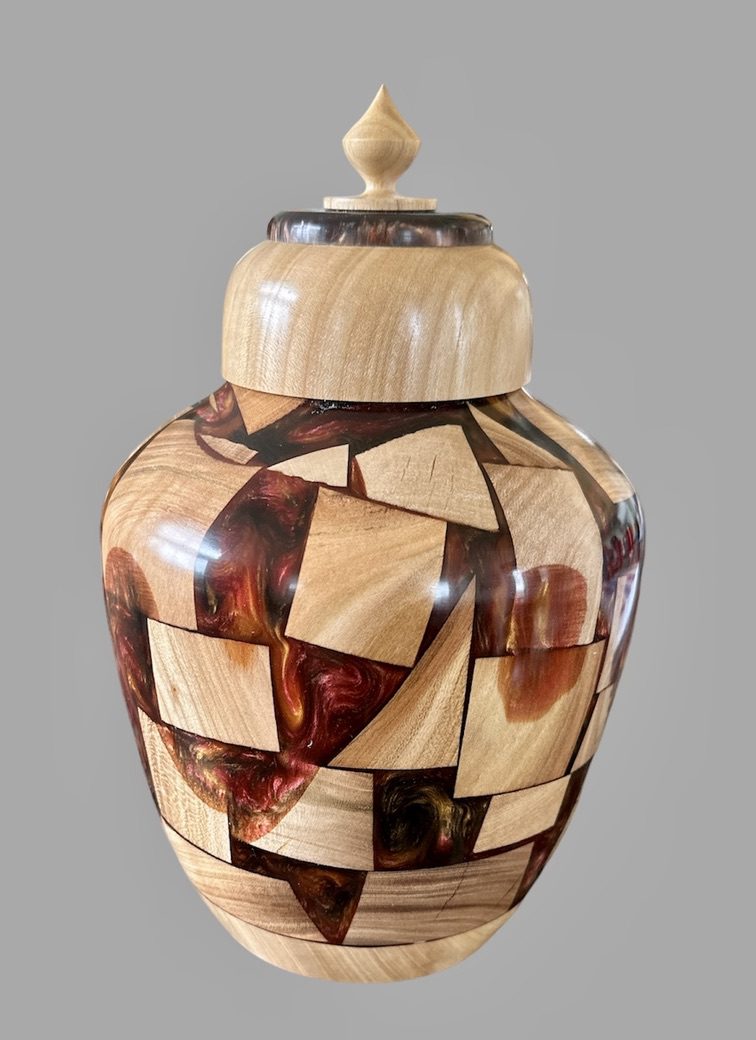 A wooden vase with a lid is shown.
