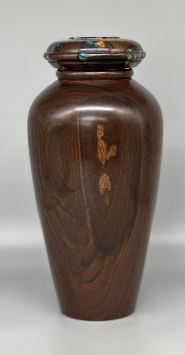 A wooden vase with some brown and black designs