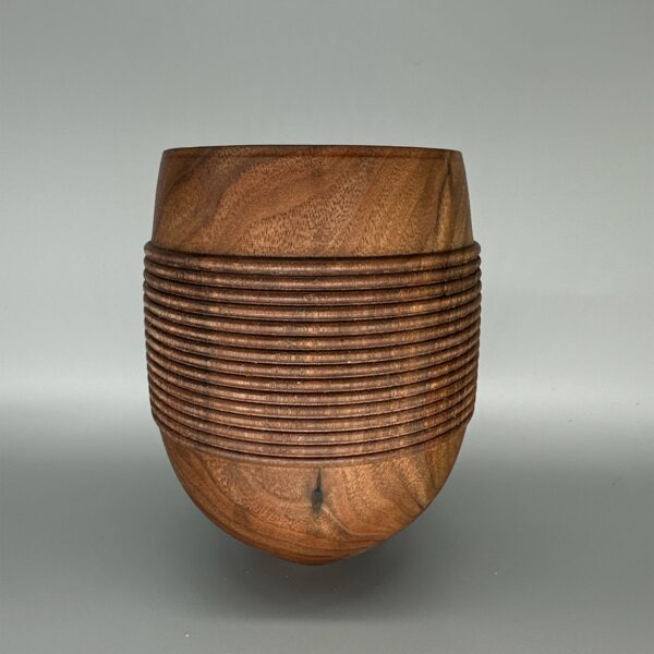 A wooden bowl with a pattern of lines on it.