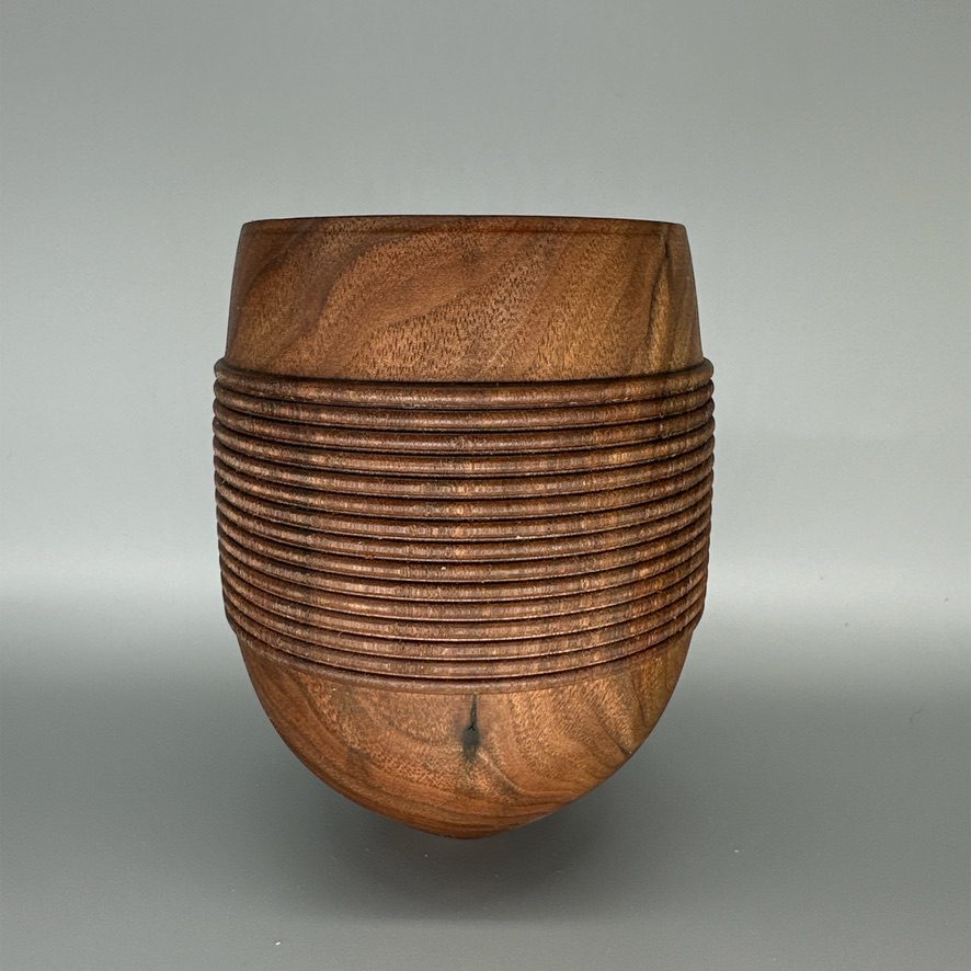 A wooden bowl with a pattern of lines on it.