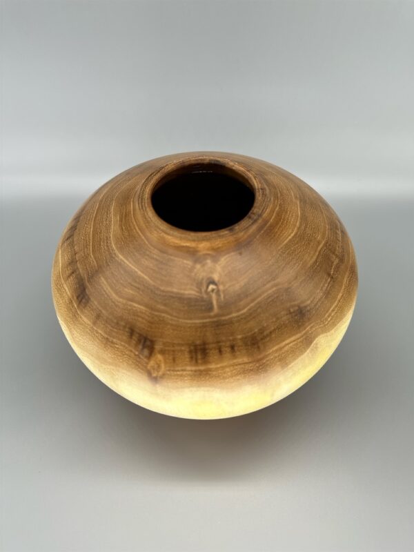 A wooden bowl sitting on top of a table.