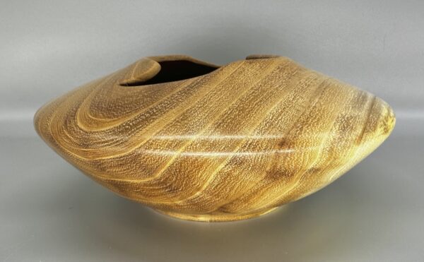 A wooden bowl with a black top on the bottom.