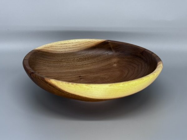 A wooden bowl with yellow and brown design.