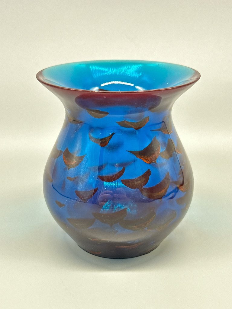 A blue vase with brown and black design on it.