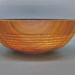 A wooden bowl with a pattern of lines on it.