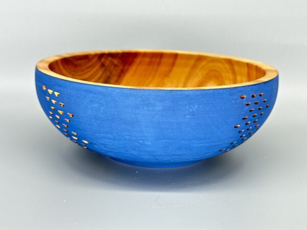 A blue bowl with a wooden rim and holes in it.