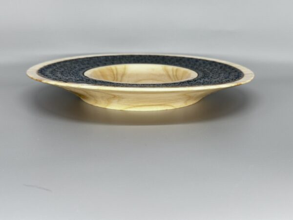 A gold and black bowl sitting on top of a table.