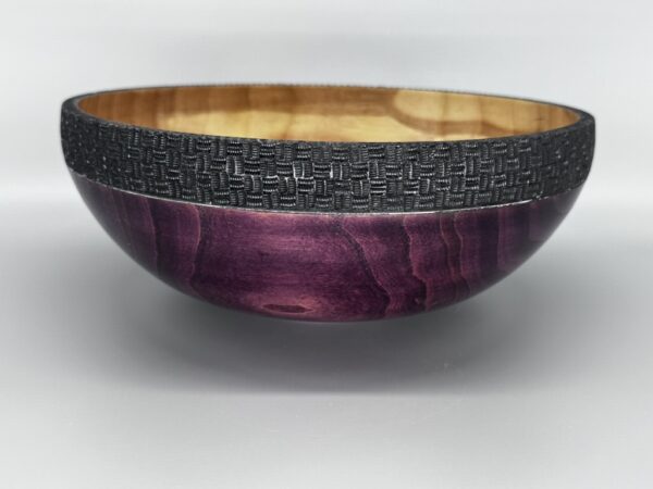 A bowl with purple and black wood on top of a table.