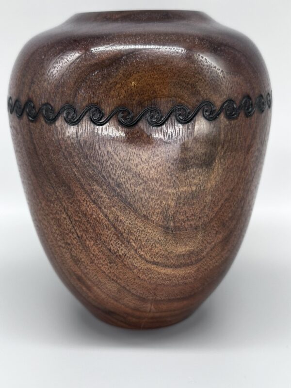 A wooden vase with black lines on the side.